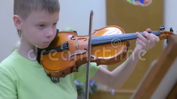 在学校音乐课上练习拉小提琴的少年视频的预览图