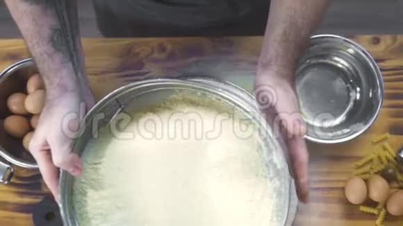 顶景厨师通过筛筛筛面粉做面团面包师用筛把面粉倒入面包房视频的预览图
