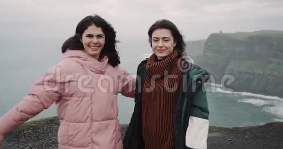 快乐的两位女士来到了莫赫悬崖屋顶上令人惊叹的地方直视着摄像机微笑视频的预览图