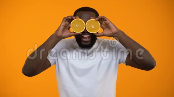 快乐的非裔美国人用半个橙子和维生素来闭上眼睛视频的预览图