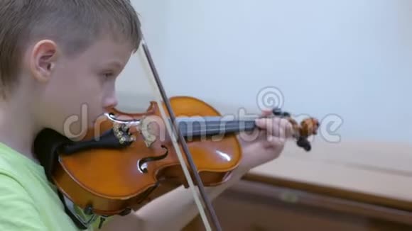 男孩在学校的音乐课上练习小提琴视频的预览图