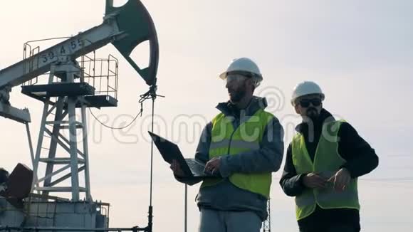 男性工程师在一个有油塔的地方讲话石油开采行业理念视频的预览图