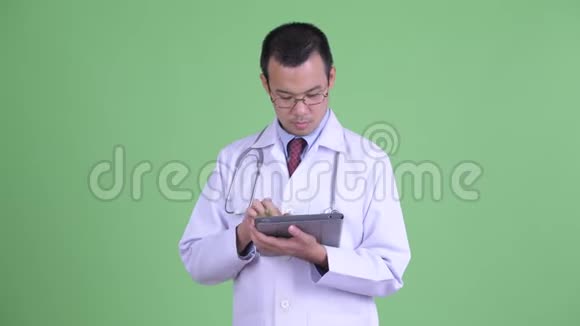 快乐的亚洲男医生在用数码平板电脑说话视频的预览图