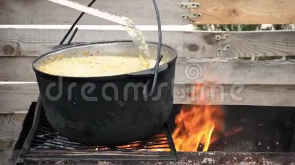 在烤架上用勺子搅拌特写准备了带肉的小麦麦片视频的预览图
