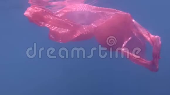 水母从塑料中释放出来游出蓝色塑料袋塑料污染水下喷丸视频的预览图