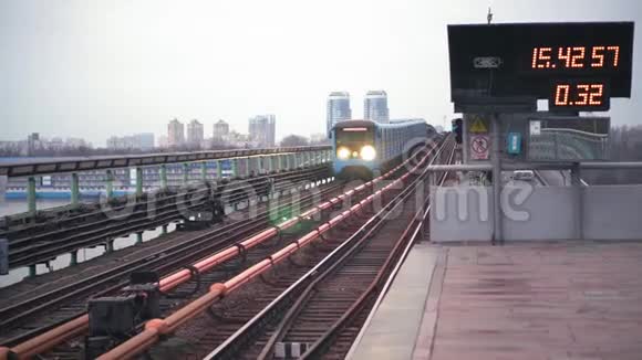 蓝色地铁列车到达基辅宽德涅珀河大桥上的地面站视频的预览图