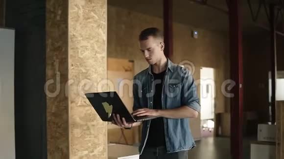 迷人的集中精力的年轻商人手里拿着一台笔记本电脑走路打字白人积极分子视频的预览图