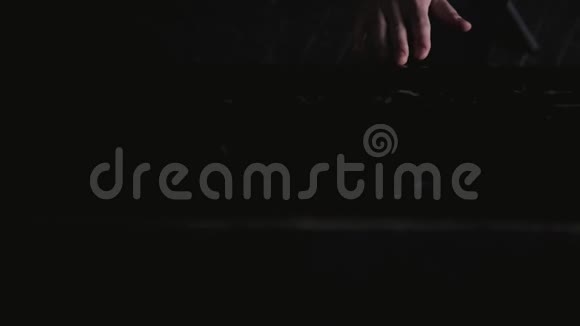 近距离拍摄一位艺术家打开并擦拭旧的黑色钢琴视频的预览图