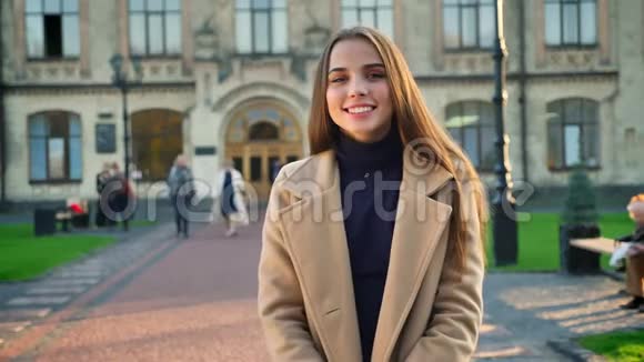 美丽的白种人微笑的女性站在美丽的城市文化建筑附近看镜头随意视频的预览图
