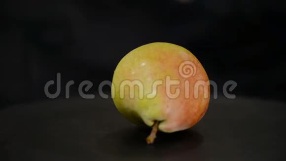 成熟多汁梨的特写在黑色背景上旋转视频的预览图