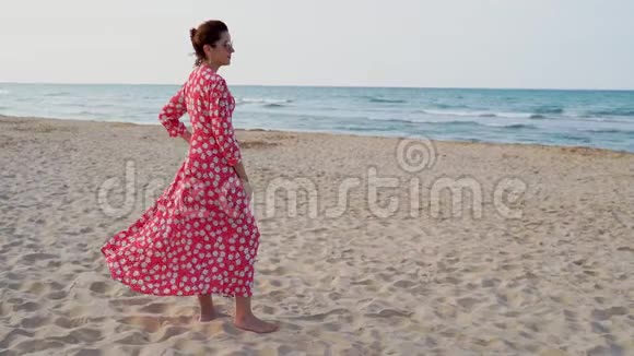日落时分一位身穿红色裙子的美女在地中海缓慢地观看视频的预览图