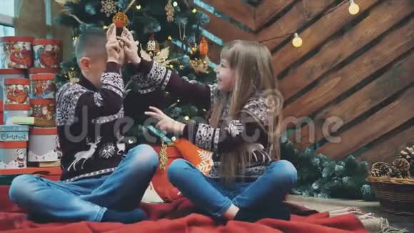 穿着羊毛衫的孩子们在圣诞节的时候用双手竖起大耳朵在木制背景上伸出舌头视频的预览图