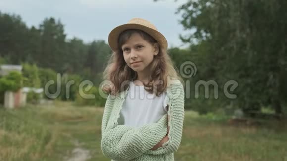 美丽的微笑女孩戴着针织毯的帽子自然背景视频的预览图