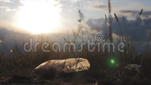 夕阳下草地上的白色塑料袋塑料污染的概念对地球的伤害视频的预览图