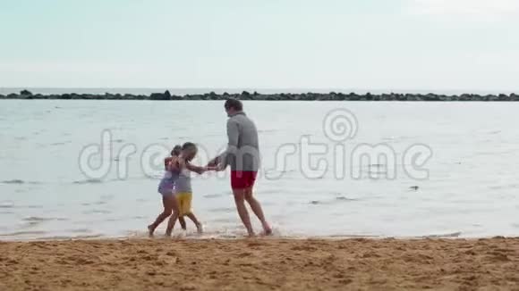 爸爸儿子和女儿一起玩跳舞和跳跃夏季视频的预览图