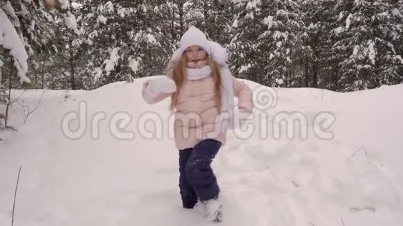 滑稽的白人女孩走在雪松树林里跳舞飘落到白雪视频的预览图
