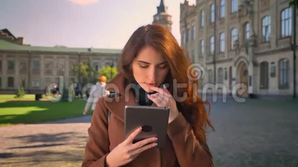 秋日阳光下拍摄的白种人黑发女人站着在古建筑上挥舞着她的石碑集中了视频的预览图