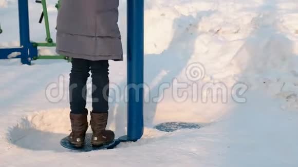 在冬季公园里一位身材矮小的女子腿正在滚动模拟器上做运动后景视频的预览图