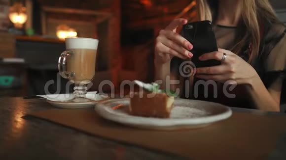 女人用智能手机在咖啡馆做照片蛋糕视频的预览图