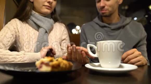 年轻夫妇在咖啡馆的浪漫约会中牵手一起享受时光视频的预览图