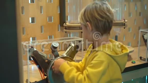 一个小男孩参观儿童科学博物馆的慢镜头他用手泵压缩空气以便视频的预览图