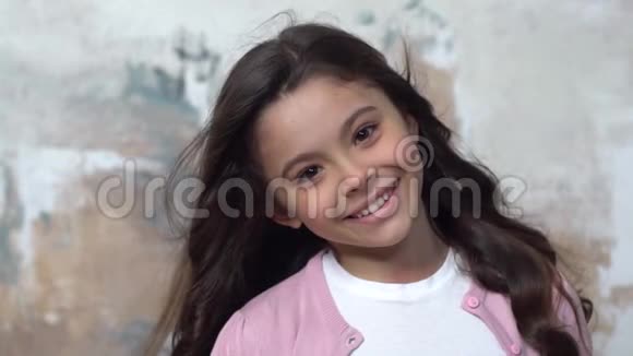 一个小女孩独自被隔离在墙上微笑着快乐着视频的预览图