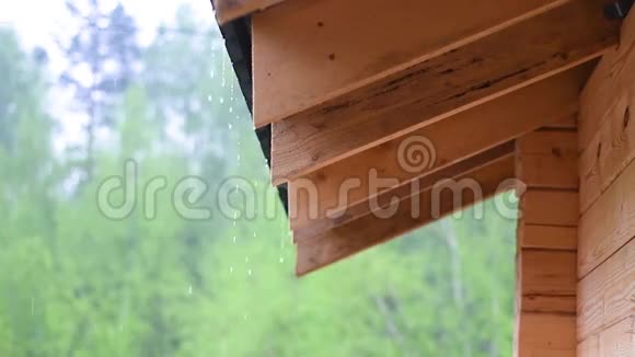 阴雨天气下大雨从一间木屋的屋顶下流下来视频的预览图
