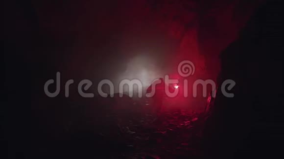一位地质学家检查黑暗洞穴的剪影手里拿着红色信号弹库存录像科学家探索石头视频的预览图
