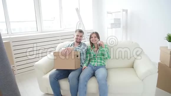 购租房地产的概念幸福的年轻夫妇带着新家的钥匙视频的预览图
