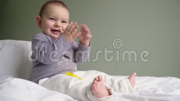 婴儿拍手坐沙发室内快乐童年时刻概念4k视频的预览图