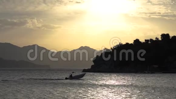 日落时一艘小船缓慢地驶进美丽的海湾视频的预览图