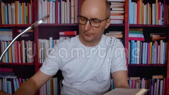 人在科学图书馆阅读有趣的百科全书书架背景视频的预览图