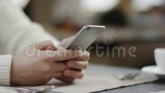 正经男人坐在桌边用智能手机视频的预览图
