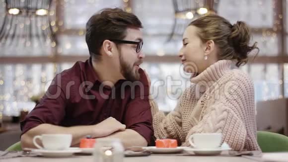 成年男女坐在咖啡馆里互相调情视频的预览图