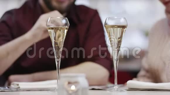 在餐馆里喝香槟和接吻的男人和女人的近镜头视频的预览图