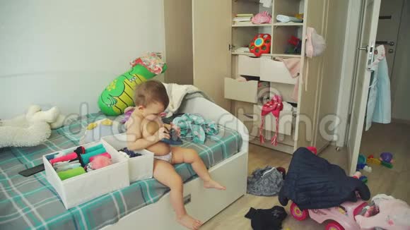 可爱的宝宝在凌乱的卧室里试衣服视频的预览图
