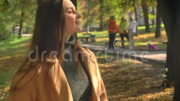 快乐的令人惊奇的留着长发的白种人女孩看着太阳站在绿色的脸上享受着阳光视频的预览图