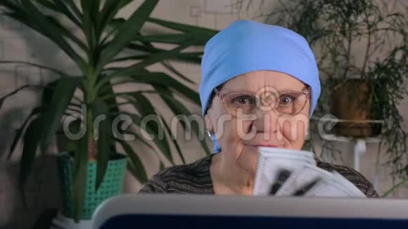一位老妇人用笔记本电脑在网上赚钱视频的预览图
