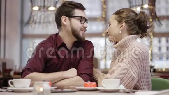 成年男子在咖啡馆里和女友聊天按摩她的耳朵玩弄她的鼻子视频的预览图