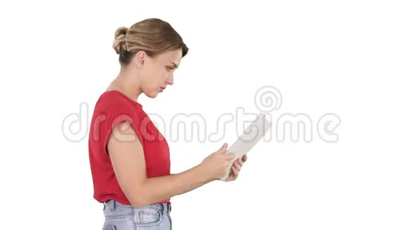 女士穿休闲服装使用数字平板行走在白色背景视频的预览图