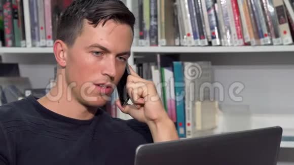 帅哥在电话里说话在笔记本上做作业视频的预览图