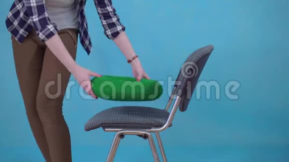 女人坐在矫形枕头上的椅子上的蓝色背景痔疮的概念接近视频的预览图