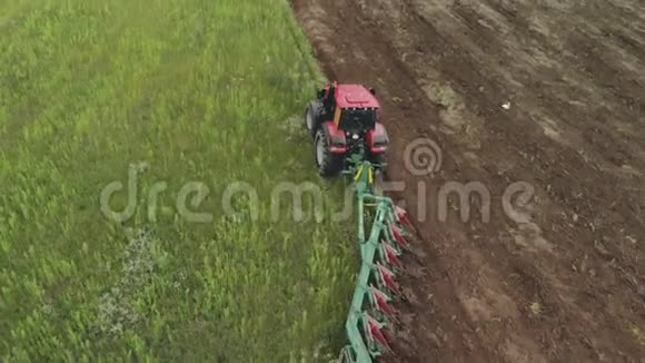农民在一台能量饱和的拖拉机上用现代犁在多云地区翻耕土层视频的预览图