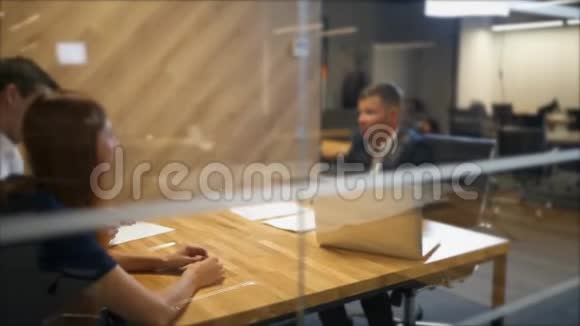 幸福的年轻夫妇坐在办公桌前看着坐在他们面前的男人拿着合同视频的预览图
