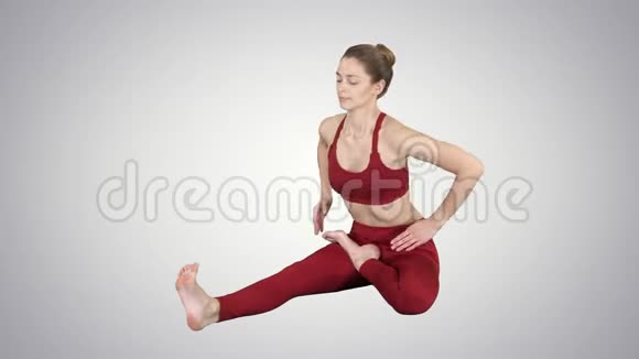 年轻有魅力的女性练习瑜伽坐在头部到膝前弯曲练习JanuSirsasana在梯度上摆姿势视频的预览图