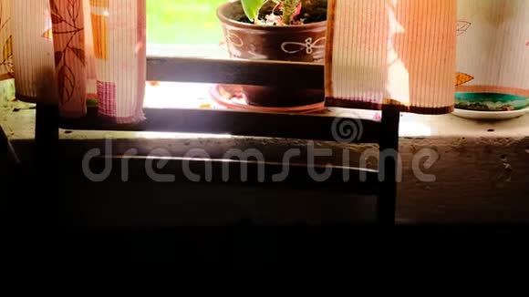 窗台上有红色天竺葵的乡村房子的窗户视频的预览图