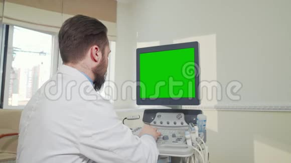 医生用绿色屏幕操作超声波扫描仪视频的预览图