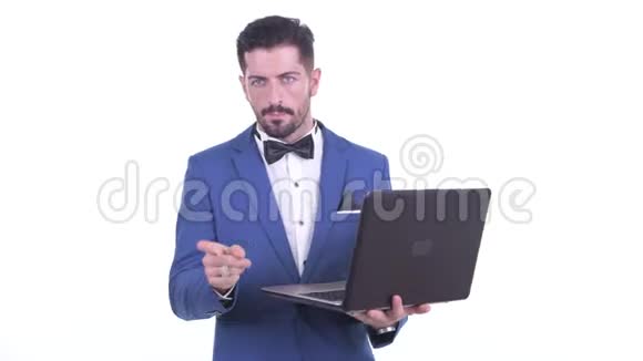 快乐的年轻大胡子商人在使用笔记本电脑时说话视频的预览图
