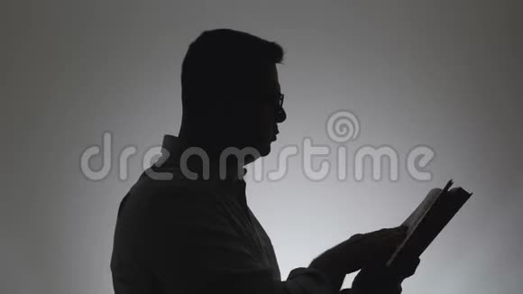 一个手里拿着书的男人的剪影一个男人情绪化地引用一本书用手做手势视频的预览图
