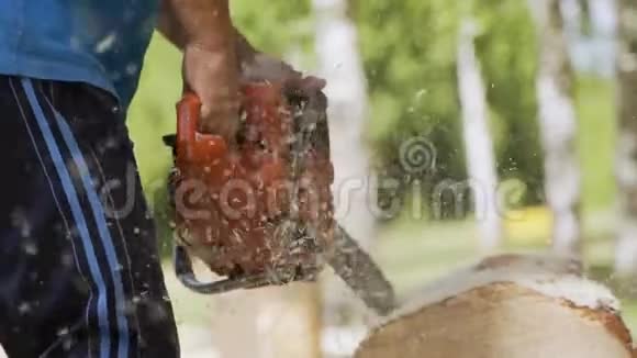 用电锯缓慢地切割木材一个人正在用电锯锯木头视频的预览图